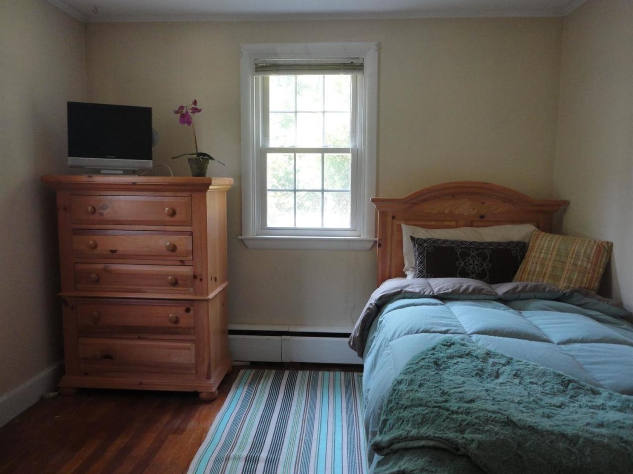 64 Elliott Road Centerville, MA 02632 - Photo 14 of 25 a bedroom with a bed and a flat tv screen on dresser