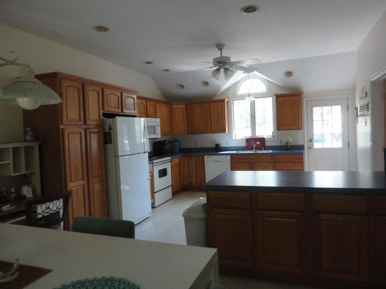 64 Elliott Road Centerville, MA 02632 - Photo 6 of 25 a kitchen with stainless steel appliances granite countertop a refrigerator a sink dishwasher a stove and white countertops with wooden floor