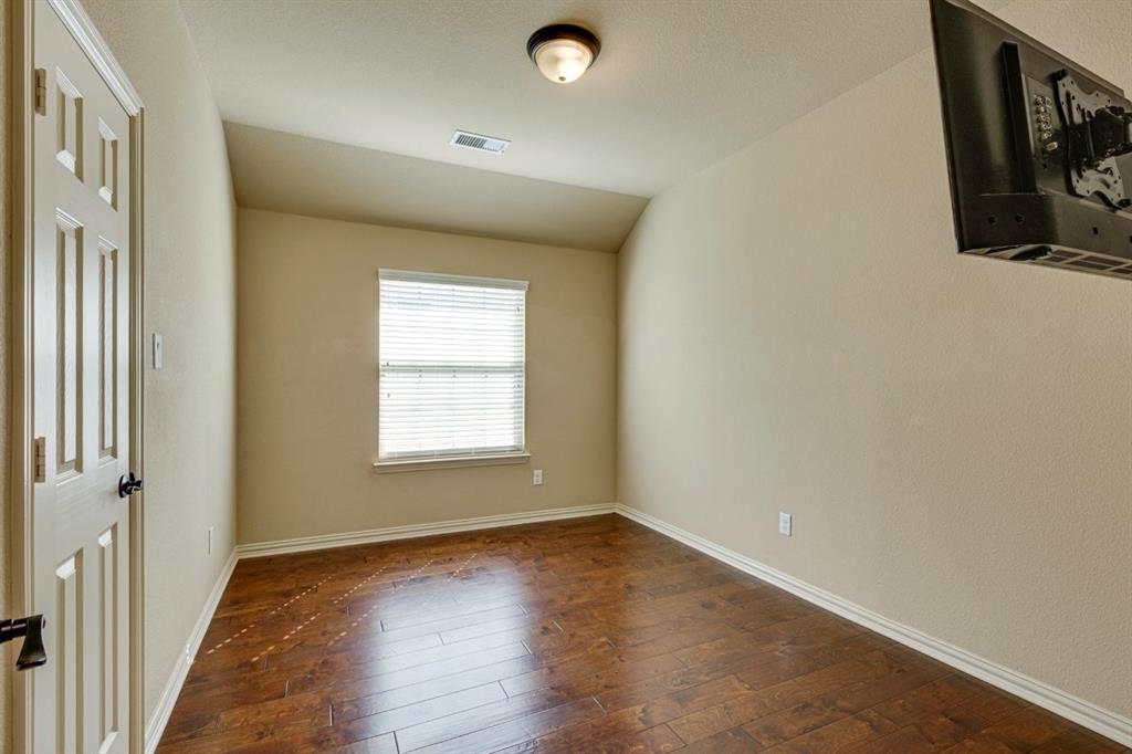1522 Blue Jay Road Garland, TX 75043 - Photo 29 of 32 Room featuring wood-finish flooring, neutral wall tones, and white trim