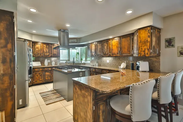 a kitchen with stainless steel appliances granite countertop a sink stove and refrigerator