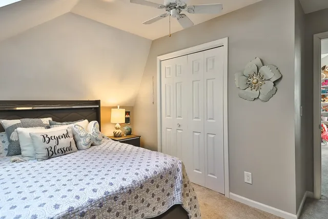 a bedroom with a bed and a lamp on dresser