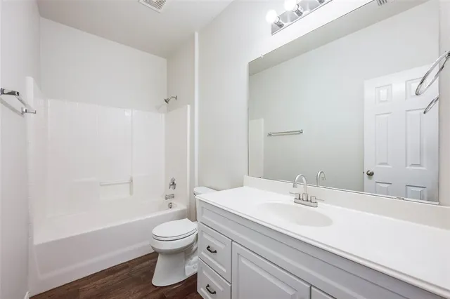 a bathroom with a sink a toilet and a large mirror