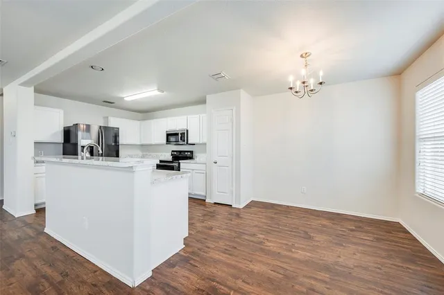 a view of kitchen with stainless steel appliances refrigerator sink and cabinets