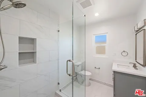 a bathroom with a shower sink and toilet