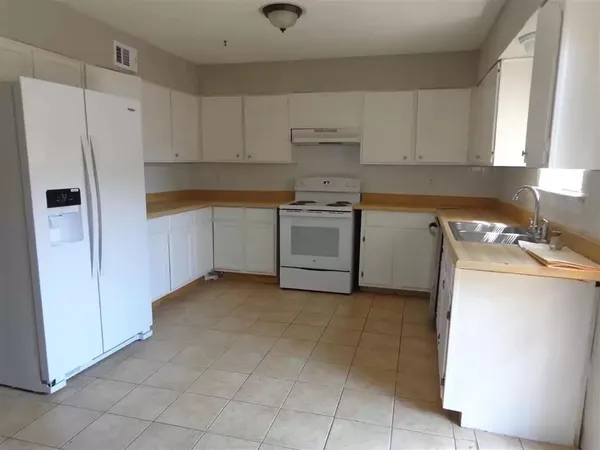 a kitchen with a refrigerator sink and cabinets