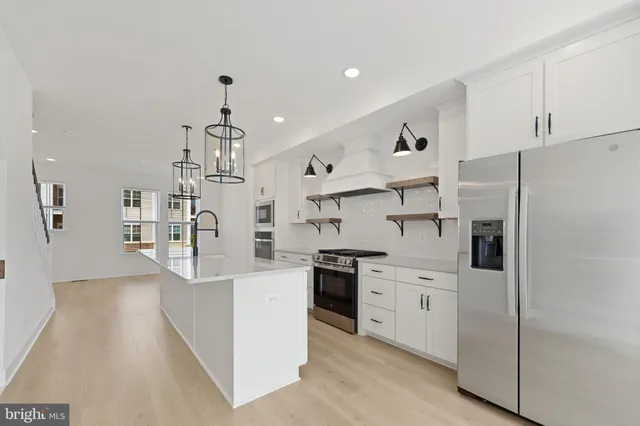 a kitchen with stainless steel appliances a refrigerator sink and cabinets