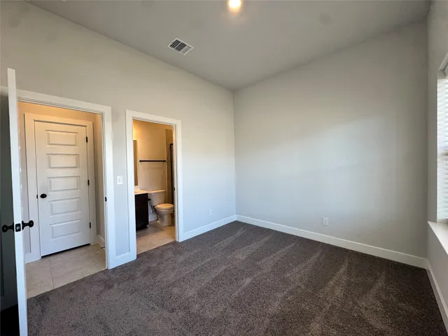 an empty room with closet and a bathroom