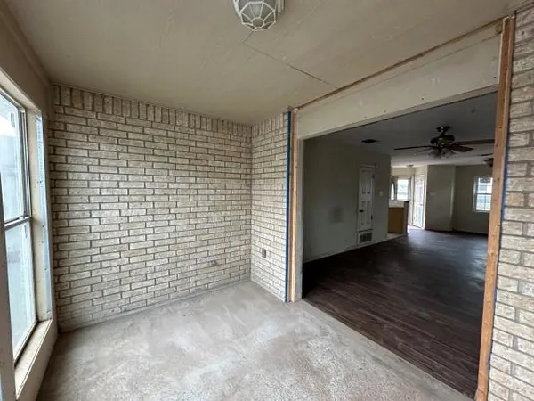 a view of empty room with wooden floor and windows