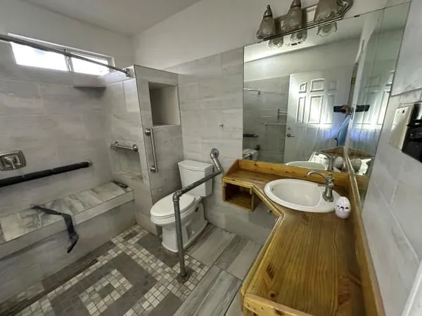 a bathroom with a sink a toilet and mirror