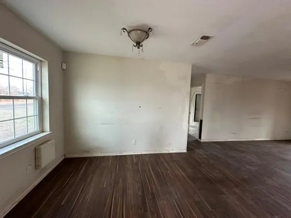 wooden floor in an empty room with a window