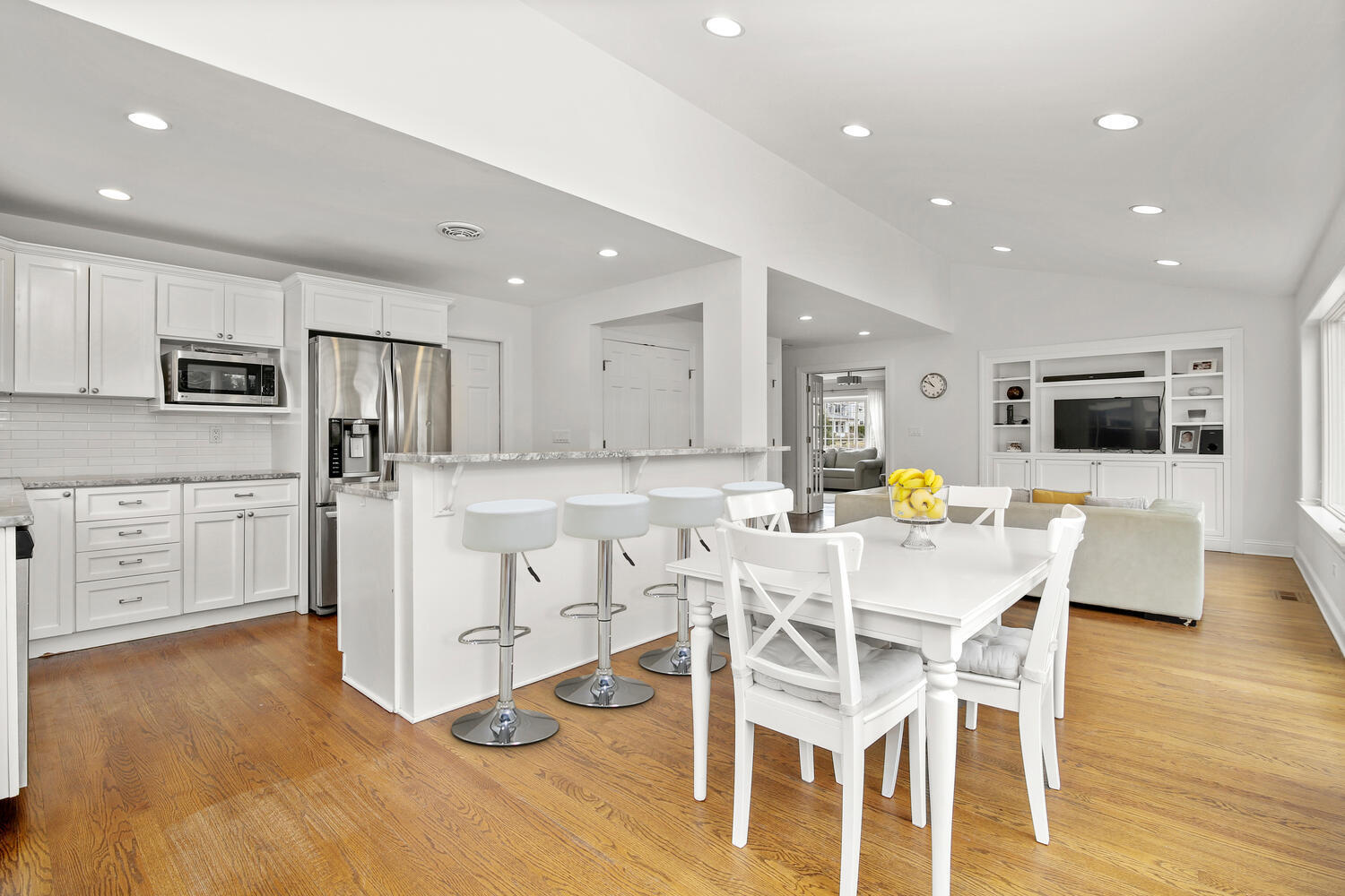 65 Summit Road Riverside, CT 06878 - Photo 7 of 20 a kitchen with stainless steel appliances kitchen island granite countertop a refrigerator a stove a white table and chairs with wooden floor