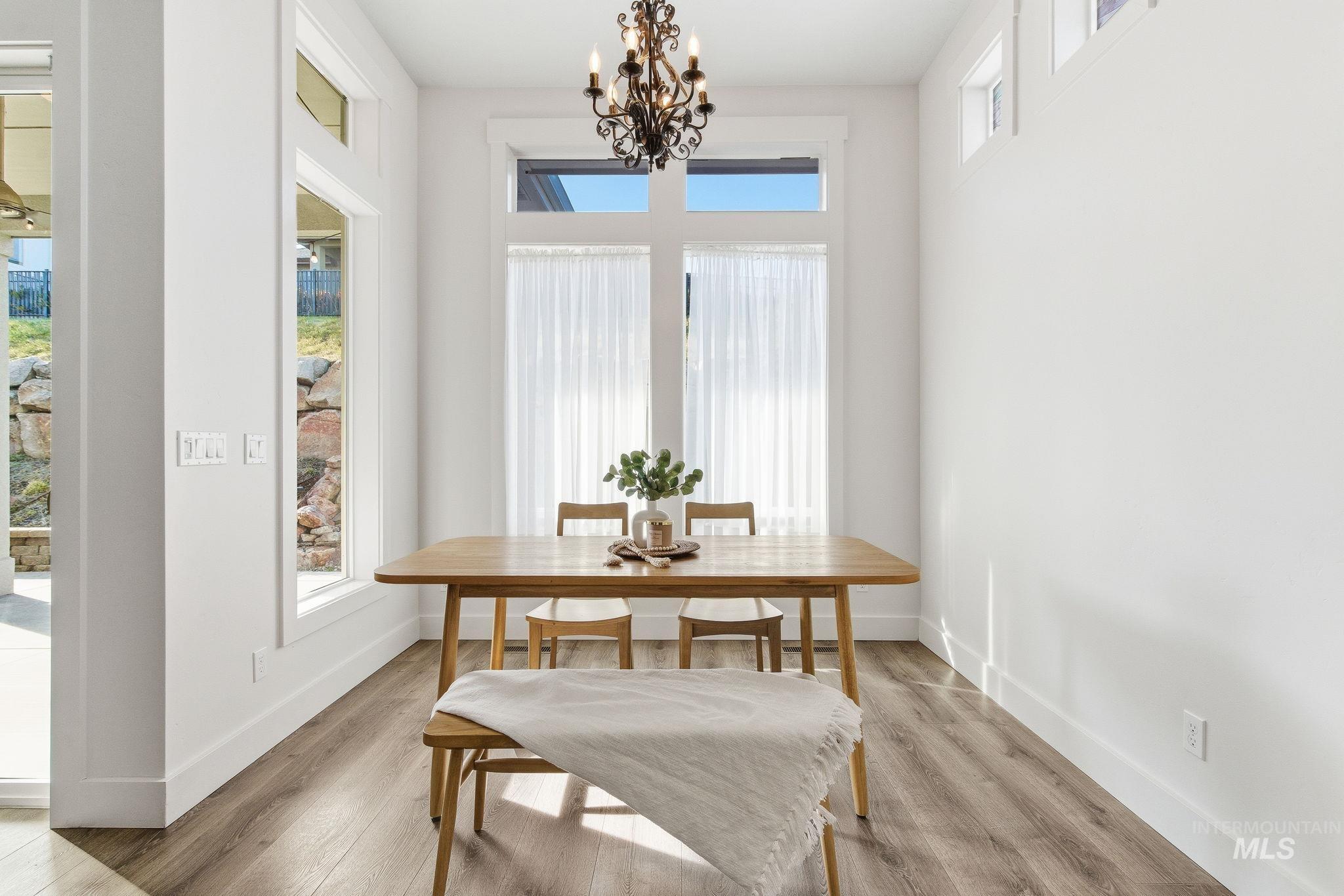 1013 East Radiant Ridge Drive Meridian, ID 83642 - Photo 15 of 36 Dining area with light wood-type flooring and a chandelier