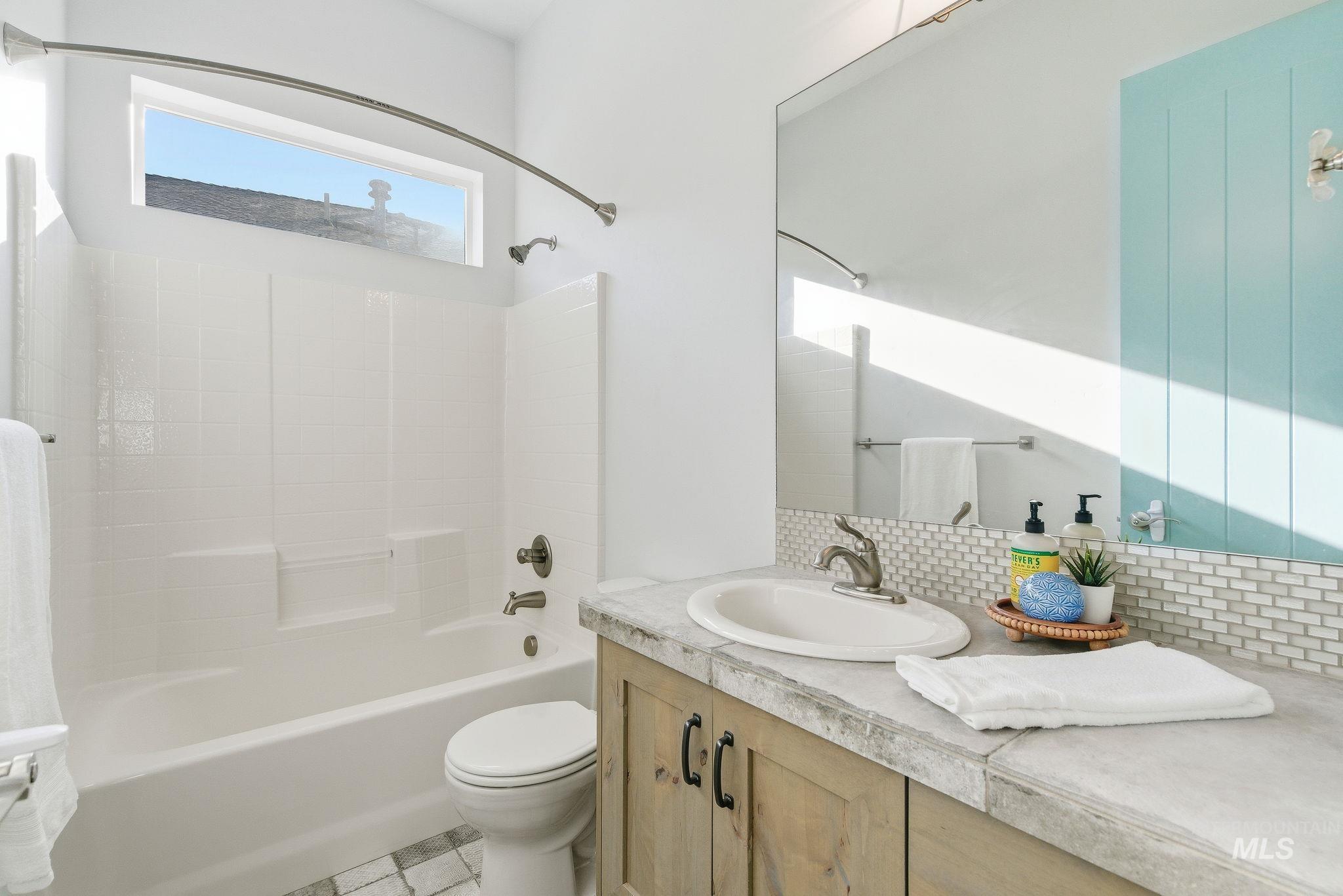 1013 East Radiant Ridge Drive Meridian, ID 83642 - Photo 18 of 36 Bathroom with vanity, bathing tub / shower combination, and backsplash