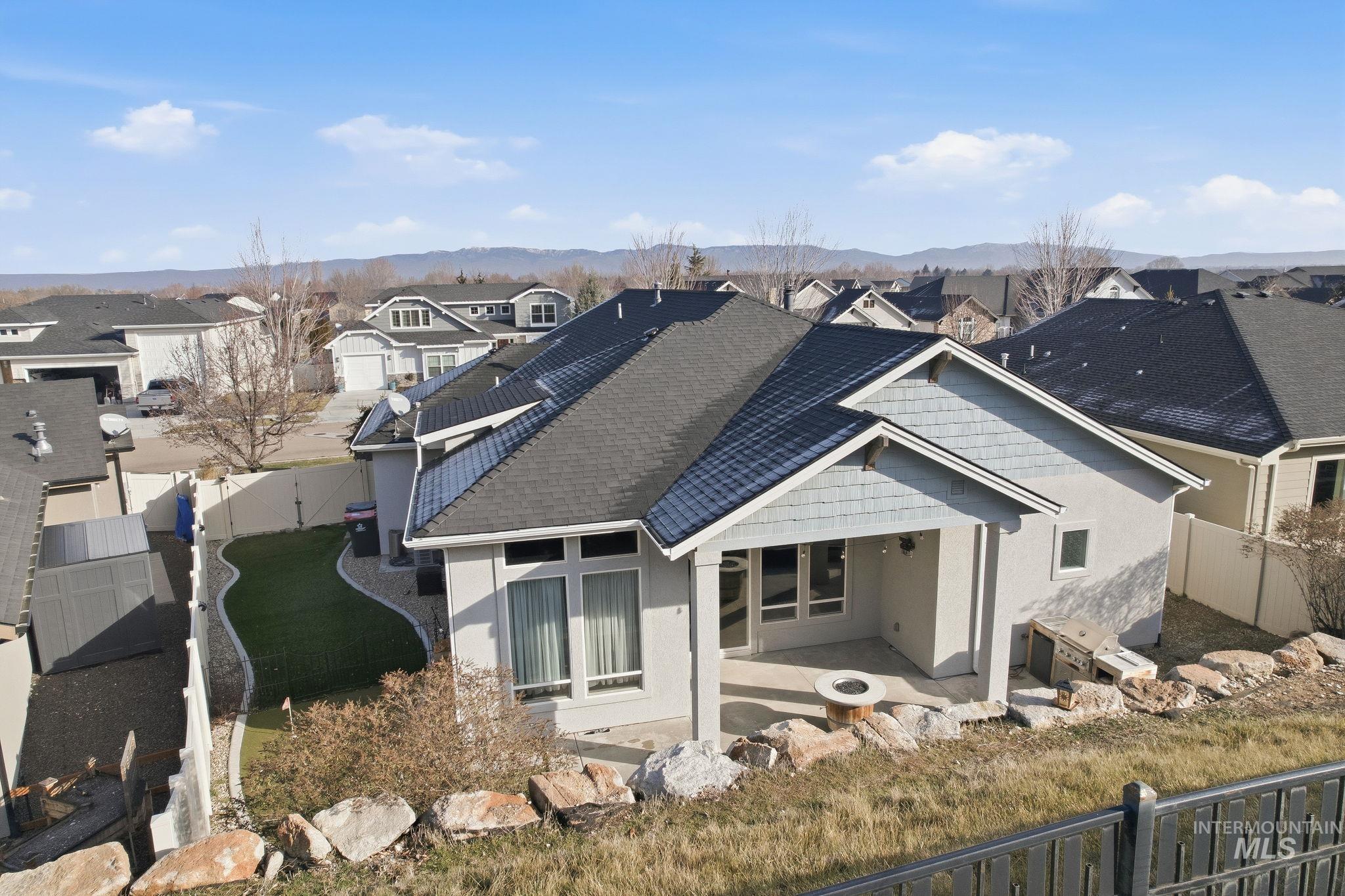 1013 East Radiant Ridge Drive Meridian, ID 83642 - Photo 31 of 36 Rear view of property featuring a fenced backyard, a residential view, stucco siding, and roof with shingles