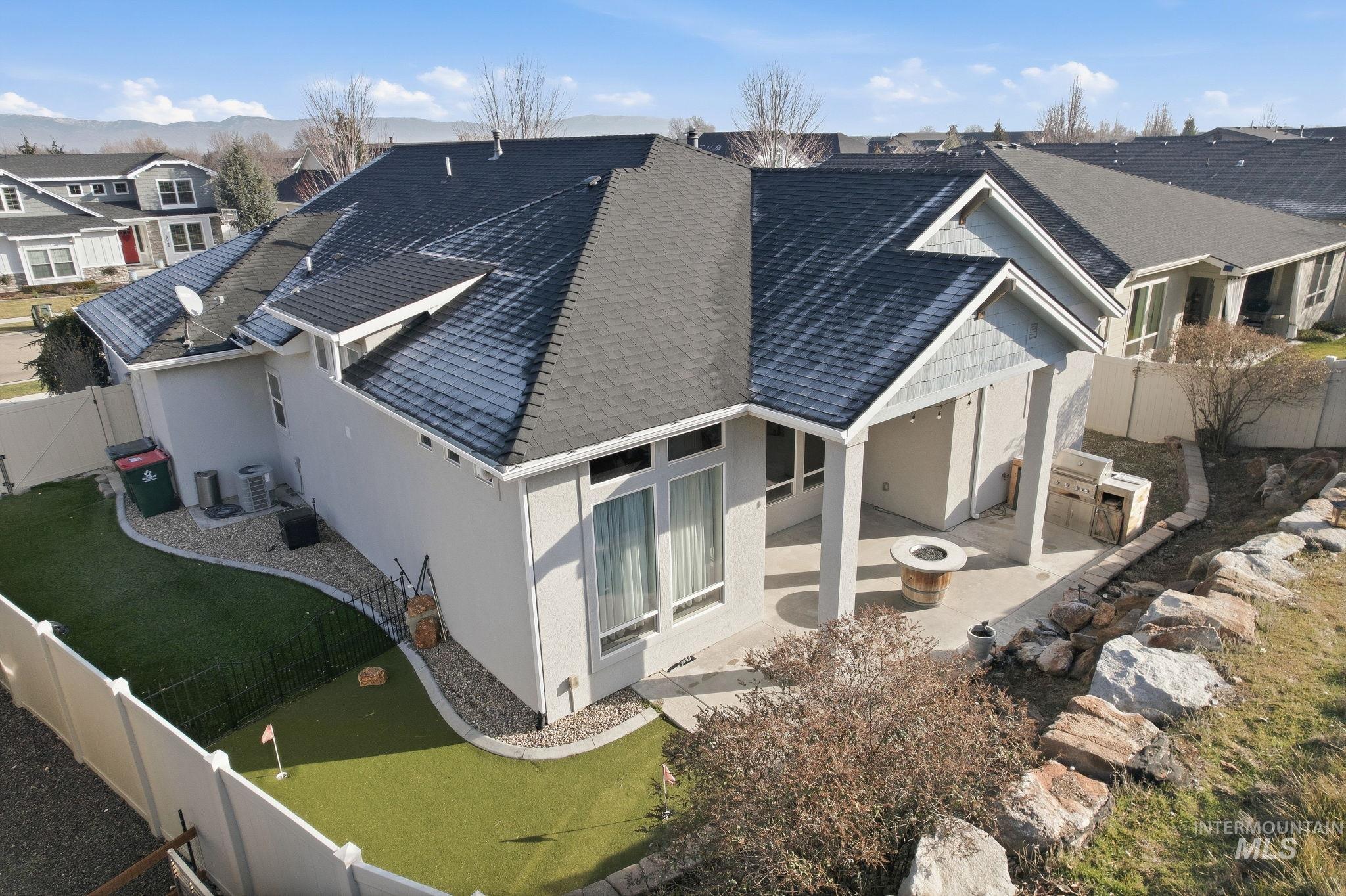 1013 East Radiant Ridge Drive Meridian, ID 83642 - Photo 32 of 36 Back of house featuring a fenced backyard, roof with shingles, a residential view, and roof mounted solar panels