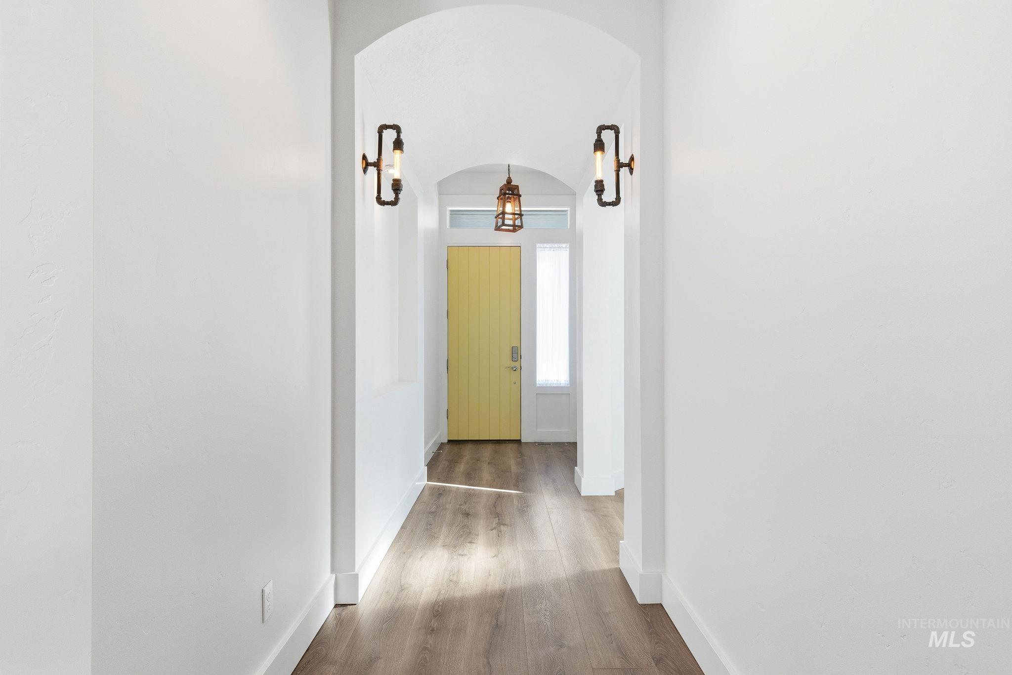 1013 East Radiant Ridge Drive Meridian, ID 83642 - Photo 4 of 36 Corridor with arched walkways and wood finished floors