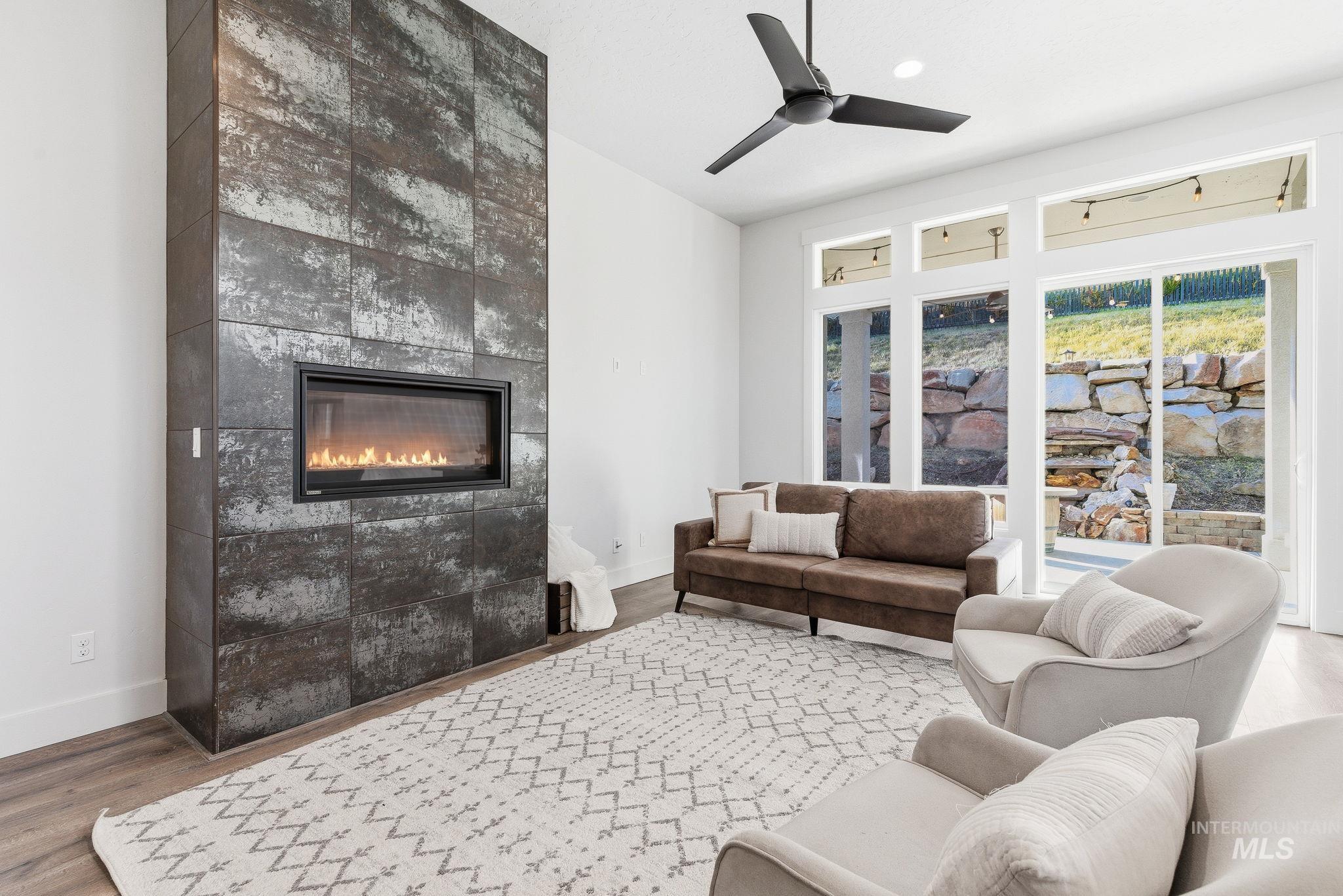 1013 East Radiant Ridge Drive Meridian, ID 83642 - Photo 6 of 36 Living room with a tiled fireplace, wood finished floors, and ceiling fan