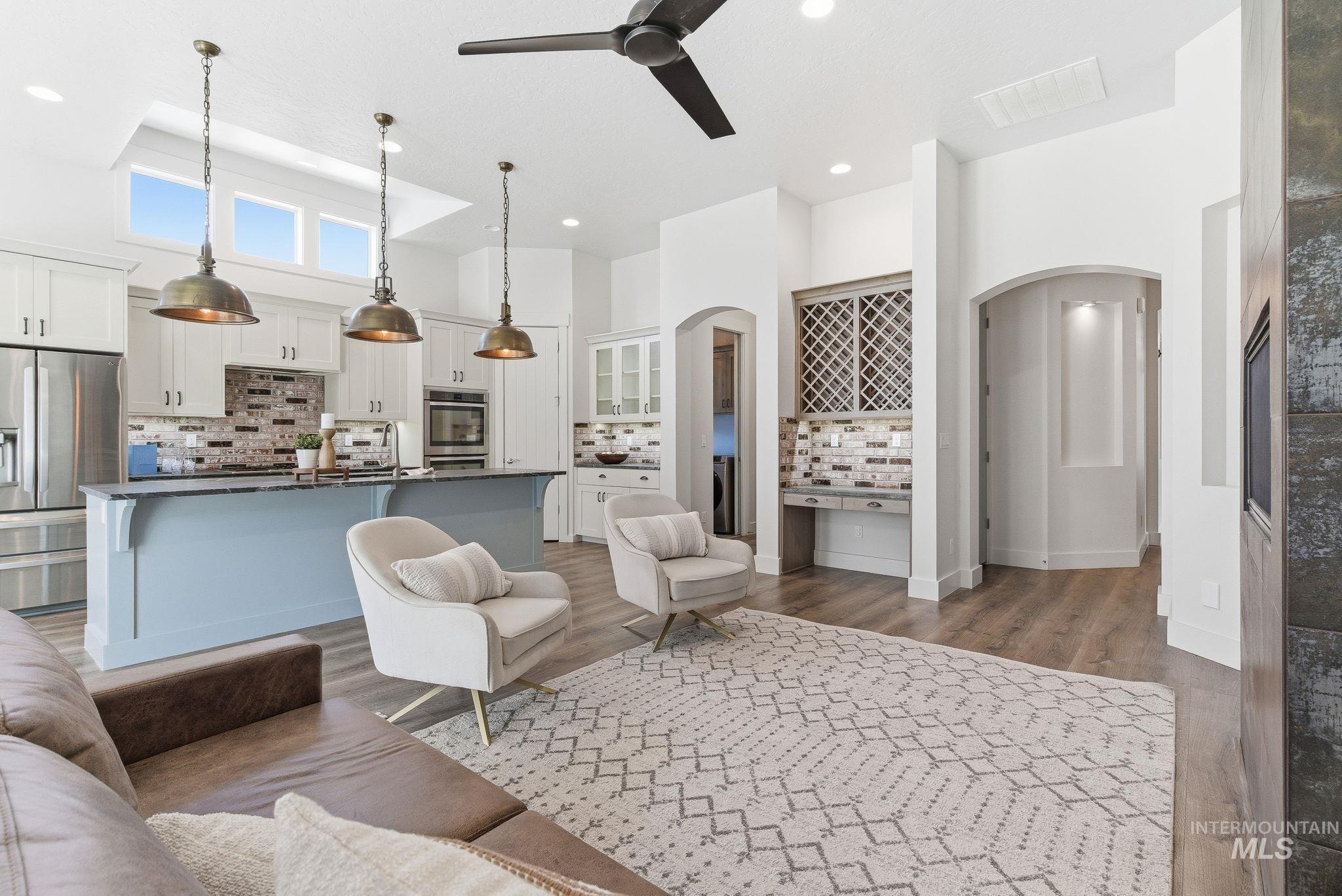 1013 East Radiant Ridge Drive Meridian, ID 83642 - Photo 7 of 36 Living area with arched walkways, wood finished floors, ceiling fan, and a towering ceiling