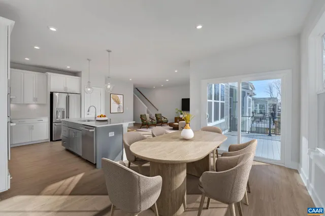 a kitchen with a dining table chairs and refrigerator