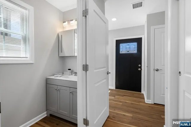 a view of hallway with sink and wooden floor