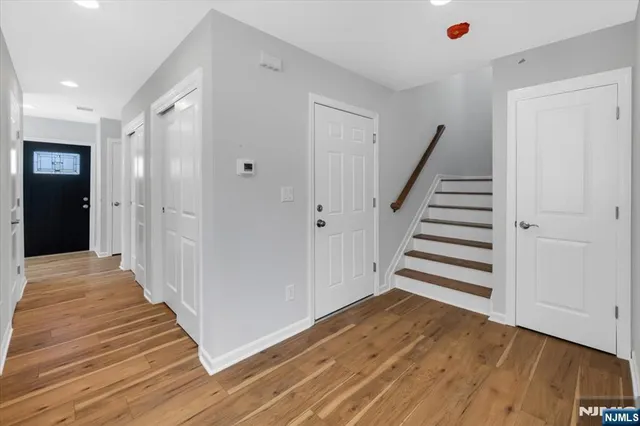 a view of a hallway with wooden floor and entryway