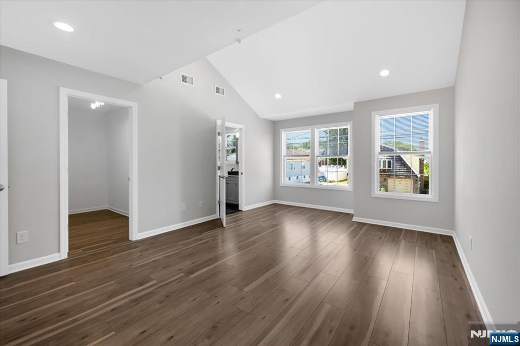 77 B Chestnut Street Lodi, NJ 07644 - Photo 22 of 36 an empty room with wooden floor and windows