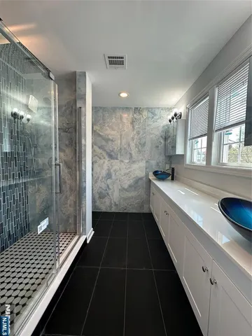 a bathroom with a double vanity sink a toilet and a shower