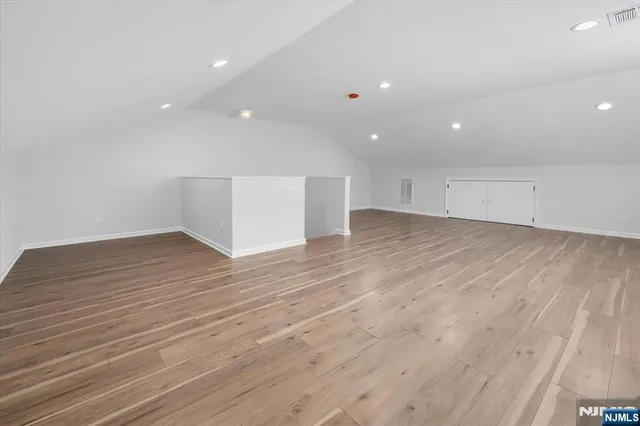 an empty room with wooden floor and entrance