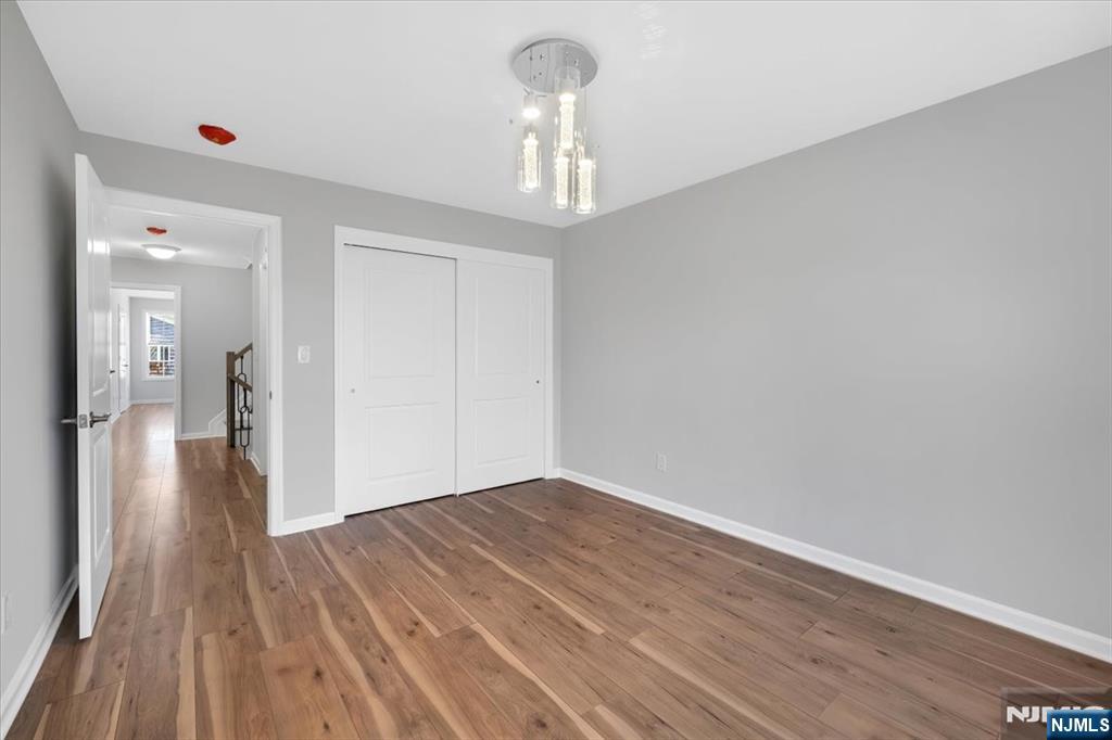 77 B Chestnut Street Lodi, NJ 07644 - Photo 31 of 36 a view of a hallway with wooden floor and a chandelier