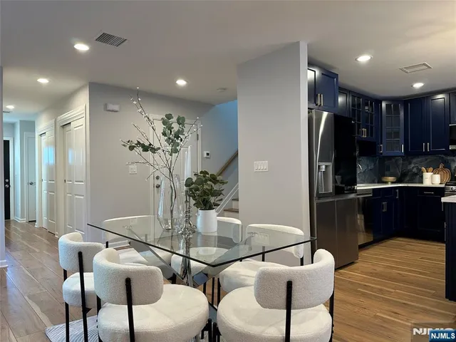 a kitchen with a refrigerator and wooden floor