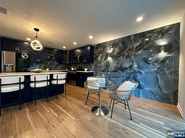 a living room with couches and kitchen view with wooden floor