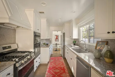 a kitchen with stainless steel appliances granite countertop a stove a sink dishwasher and a refrigerator