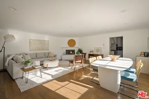 a living room with furniture a fireplace a large window and a large window