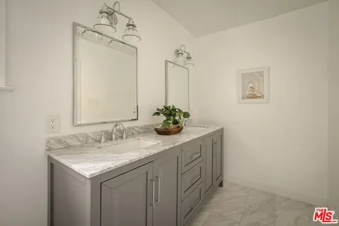 a bathroom with a granite countertop sink a toilet and shower