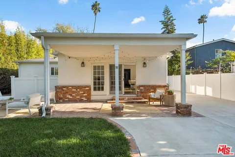 a front view of a house with a garden and patio