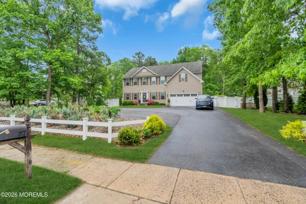 a front view of a house with a yard and shrubs