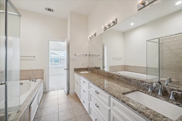 a spacious bathroom with a granite countertop sink a mirror and a bathtub