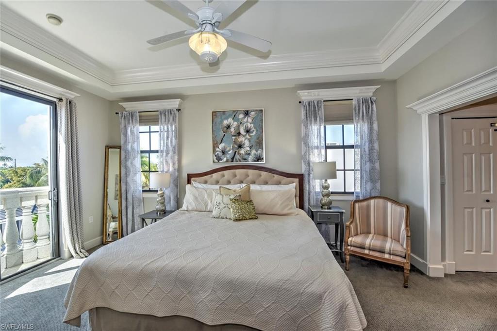 555 5th Avenue South, Unit PH1 Naples, FL 34102 - Photo 15 of 31 a bedroom with a large bed and a chandelier