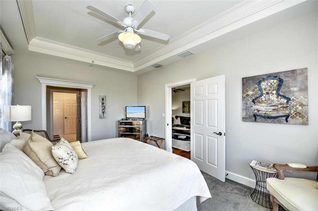 555 5th Avenue South, Unit PH1 Naples, FL 34102 - Photo 18 of 31 a bedroom with a bed and a chandelier