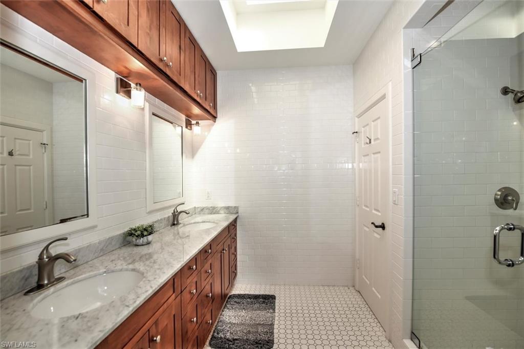 555 5th Avenue South, Unit PH1 Naples, FL 34102 - Photo 19 of 31 a bathroom with a granite countertop sink a mirror and a shower