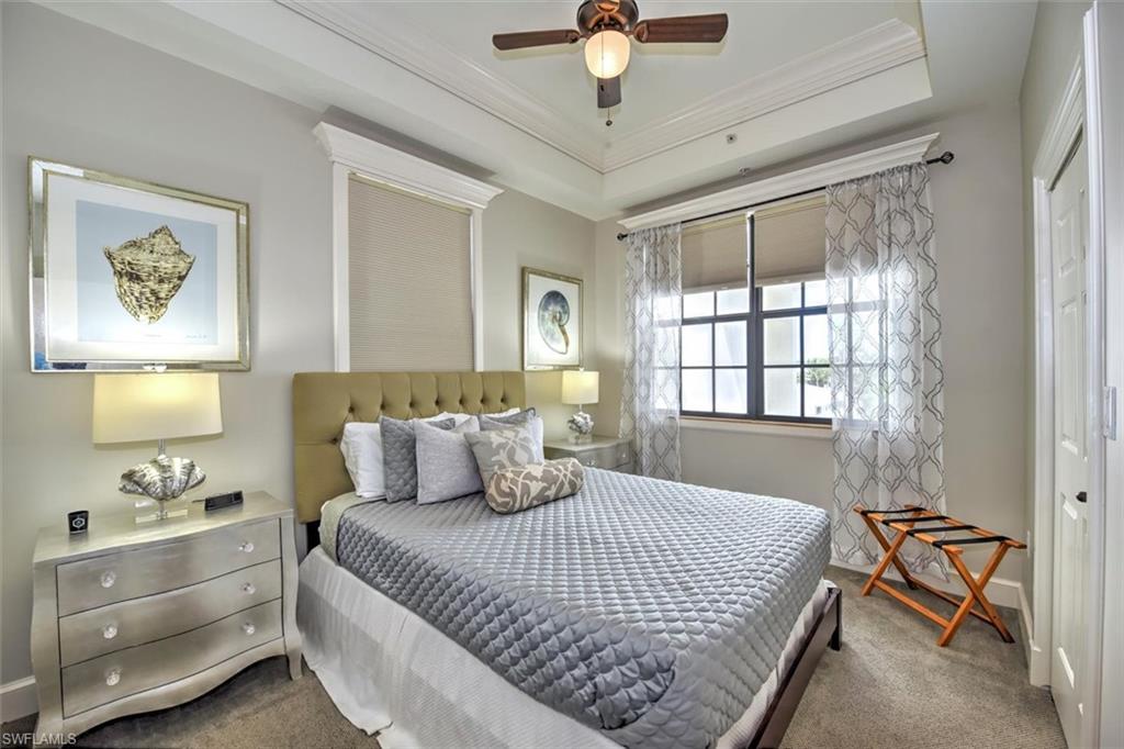 555 5th Avenue South, Unit PH1 Naples, FL 34102 - Photo 20 of 31 a bedroom with a bed and a chandelier