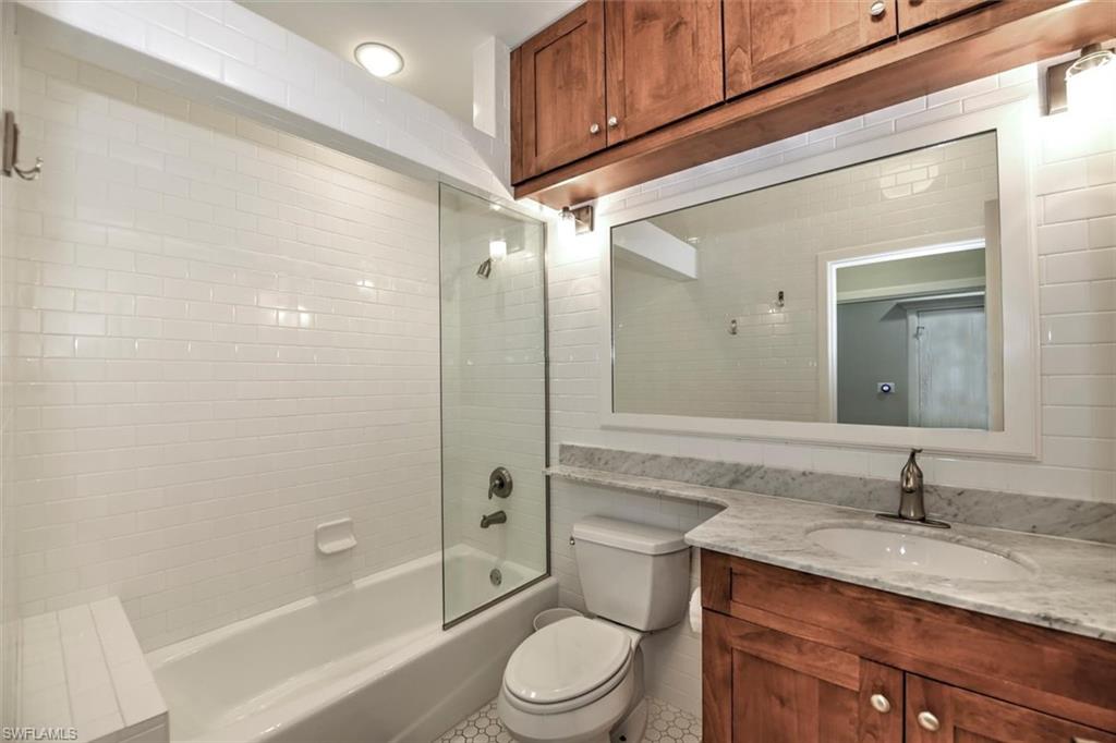 555 5th Avenue South, Unit PH1 Naples, FL 34102 - Photo 22 of 31 a bathroom with a granite countertop sink toilet a mirror and shower