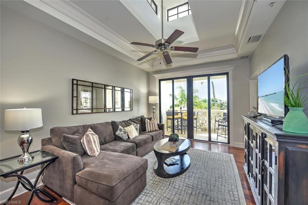 555 5th Avenue South, Unit PH1 Naples, FL 34102 - Photo 8 of 31 a living room with furniture a large window and a flat screen tv