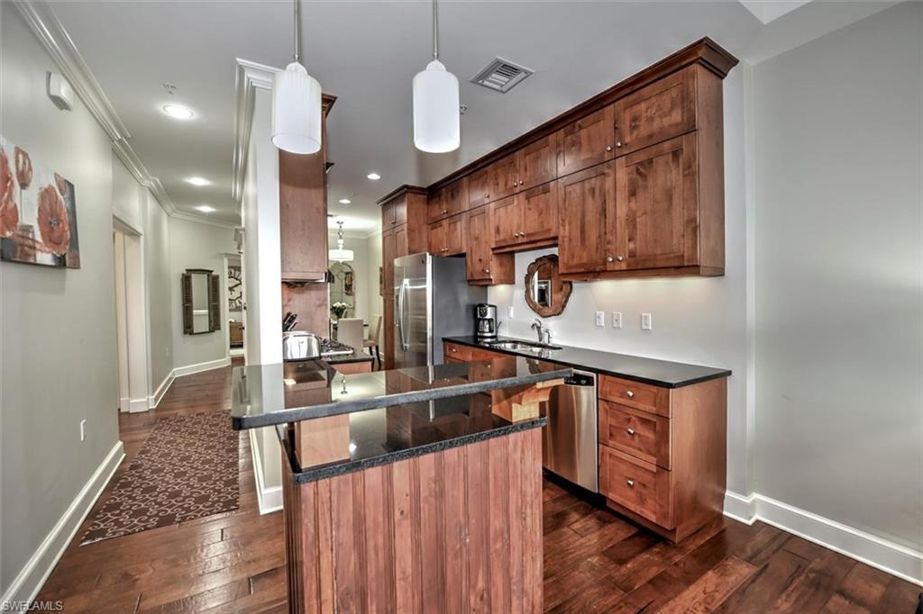 555 5th Avenue South, Unit PH1 Naples, FL 34102 - Photo 9 of 31 a kitchen with stainless steel appliances granite countertop a sink a stove and a wooden floors