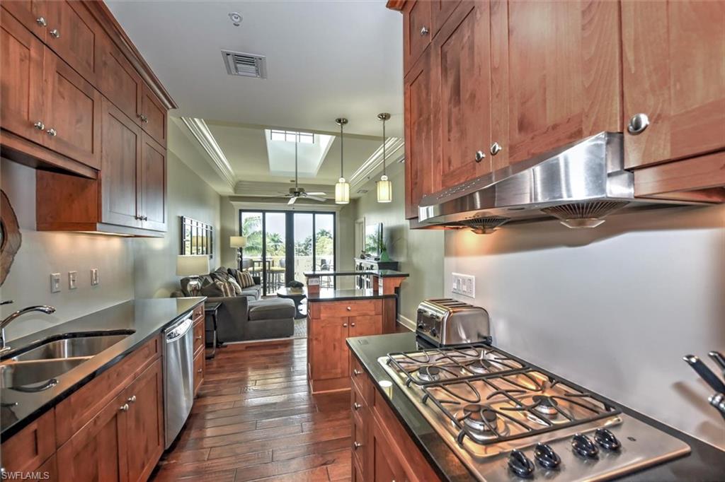 555 5th Avenue South, Unit PH1 Naples, FL 34102 - Photo 10 of 31 a kitchen with stainless steel appliances granite countertop a stove a sink dishwasher and cabinets with wooden floor