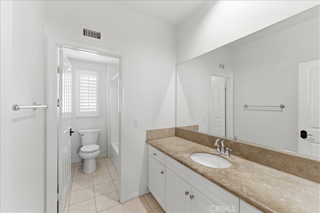 480 Santa Maria Street Anaheim, CA 92801 - Photo 9 of 17 a bathroom with a granite countertop sink a toilet and a mirror
