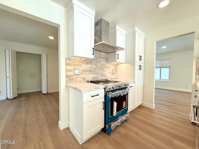 a kitchen with stainless steel appliances granite countertop a sink a stove and a wooden floors