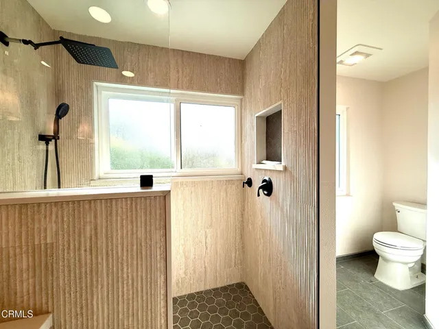 a bathroom with a toilet a sink and a window