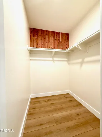 a view of a hallway with wooden floor and closet