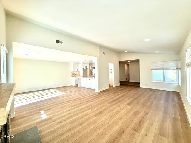 a large kitchen with kitchen island a stove a sink a center island and a wooden floor